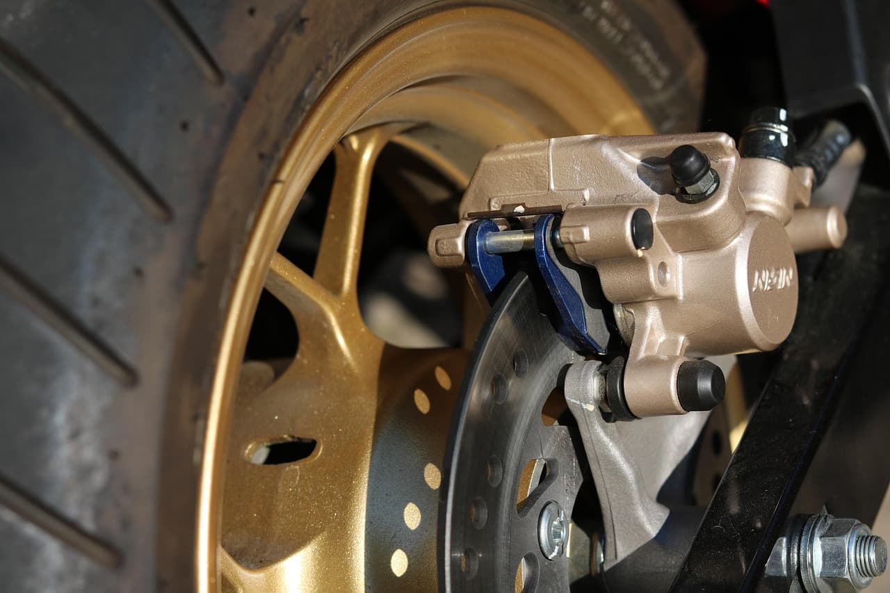 A brake calliper and disc behind an alloy wheel